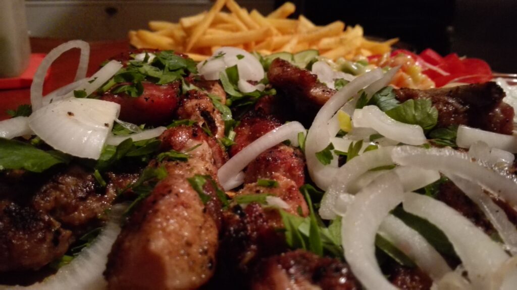 Mixed Grill with Souvlaki, burger, bacon, sausage, onions, fries & tzatziki